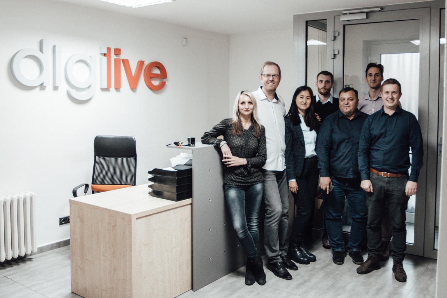 Tým iDigiLive v kanceláři pod logem iDigiLive